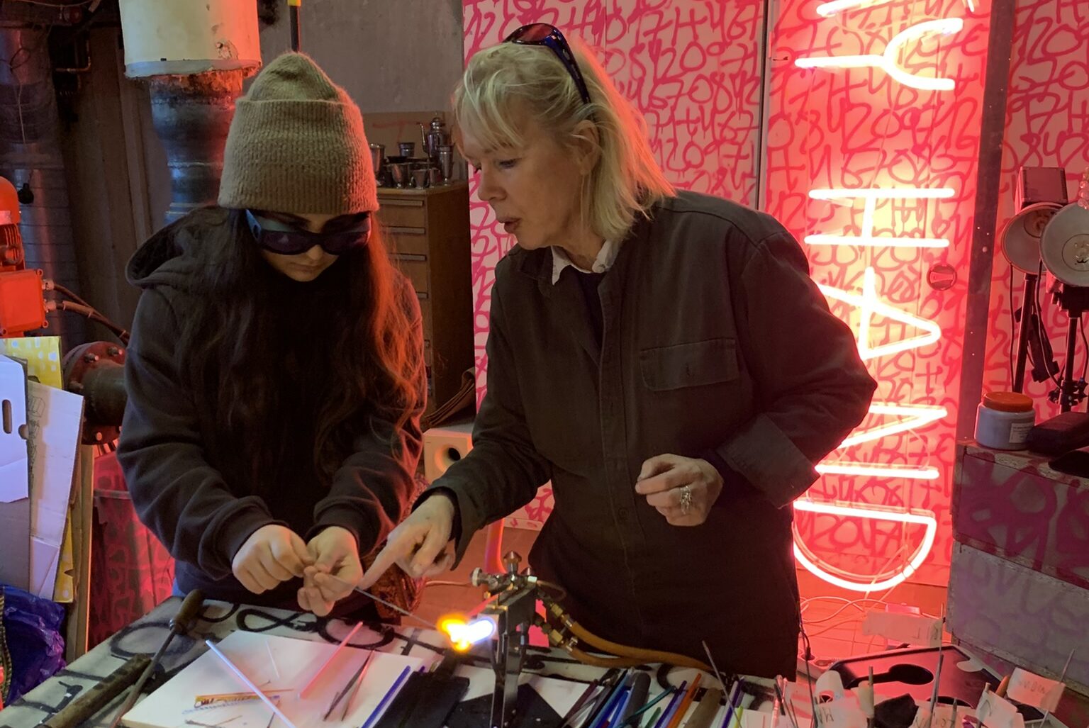 Ateljebesök i glashytta. Konstnären Lott Alfreds, tillsammans med en av eleverna.